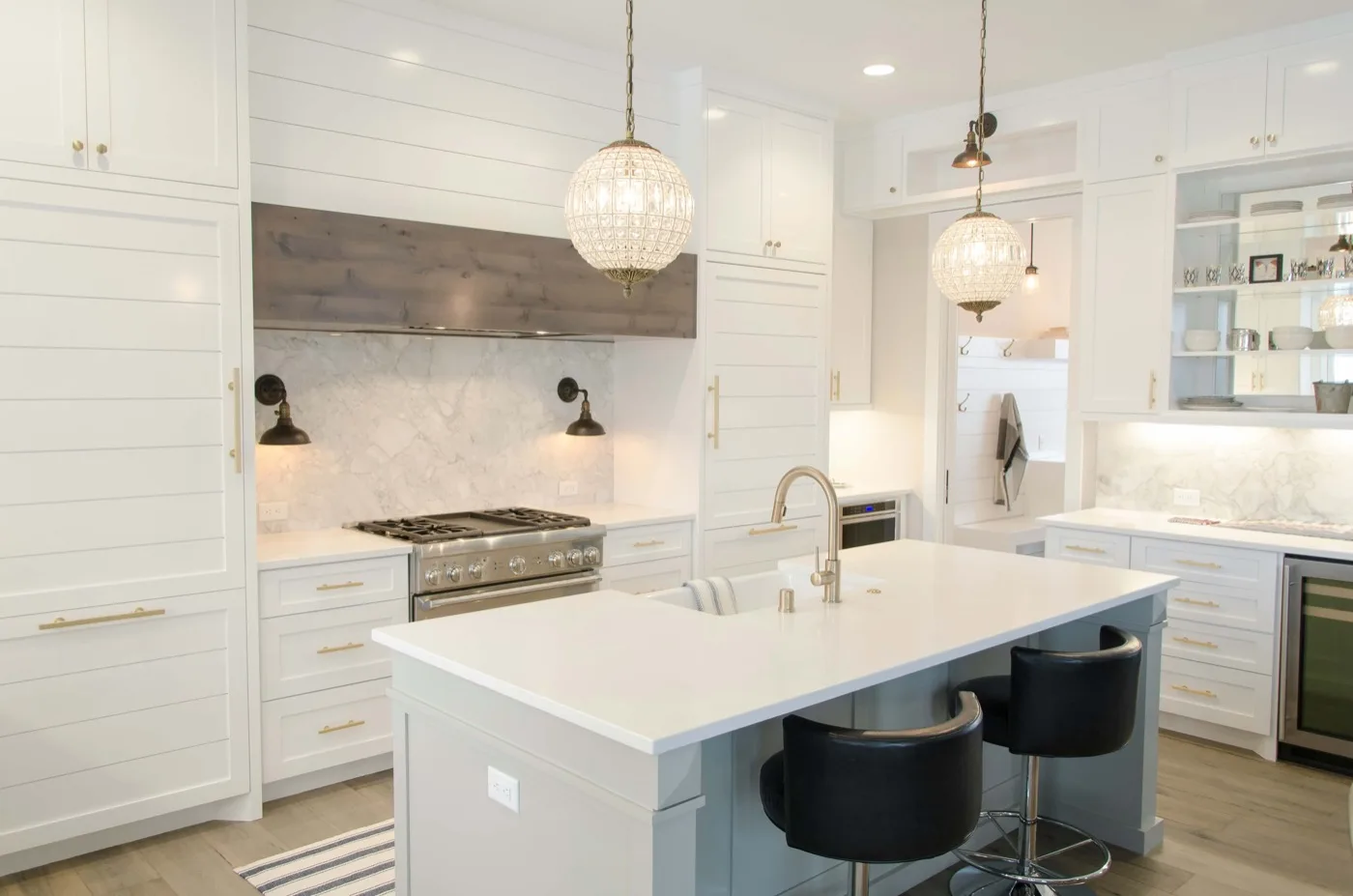 Hampton-style white kitchen with large island and gold pendant lights – kitchen remodeling Bonsall CA